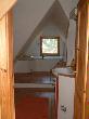 Blick ins Badezimmer. Links Duschkabine, WC, Waschbecken mit Ablage, Badewanne mit elektr. Sternenhimmel und Boddenblick.